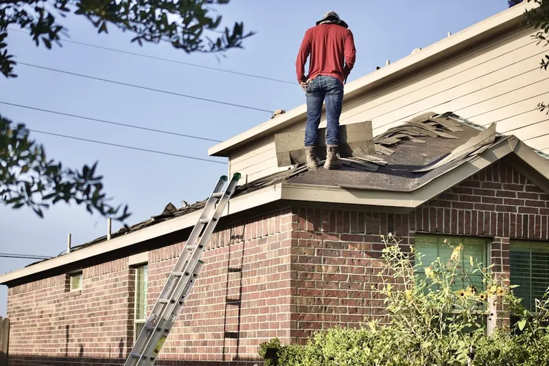 Professional roofer working on a residential roof in Winooski